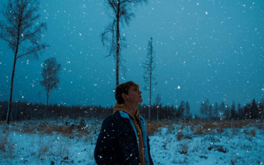 Solemn woman walking in snow.